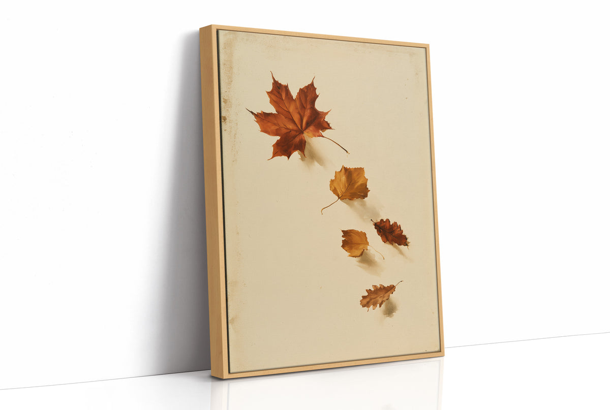 Slow Descent of the Maples, a trail of maple leaves in rust, amber and gold drifting diagonally across a warm beige ground, as a framed canvas in a natural wood frame