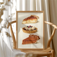 Something Sweet Keeps for Later, a still life of a cream plate holding a pie slice, a berry tart and a second pie slice, painted in caramel, cream and berry red, in a wood frame beside a wicker chair by a sunny window
