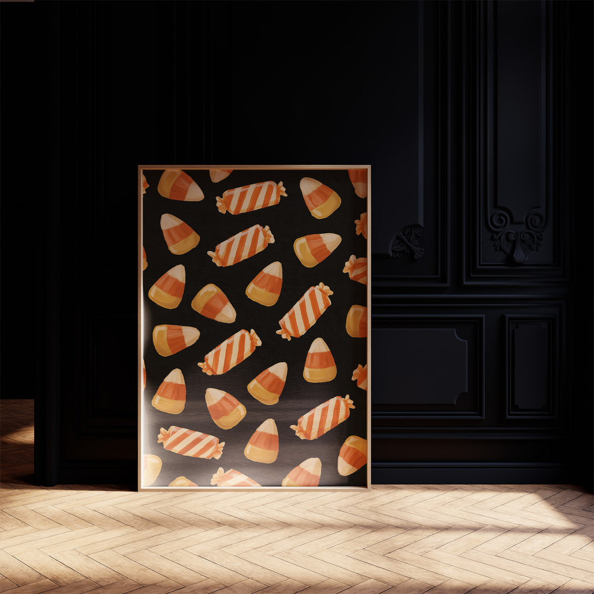 Stripes Kept for Later, a repeating pattern of candy corn kernels in cream, orange and butter yellow on a deep black ground, in a dark frame on a black paneled wall above a sunlit herringbone floor