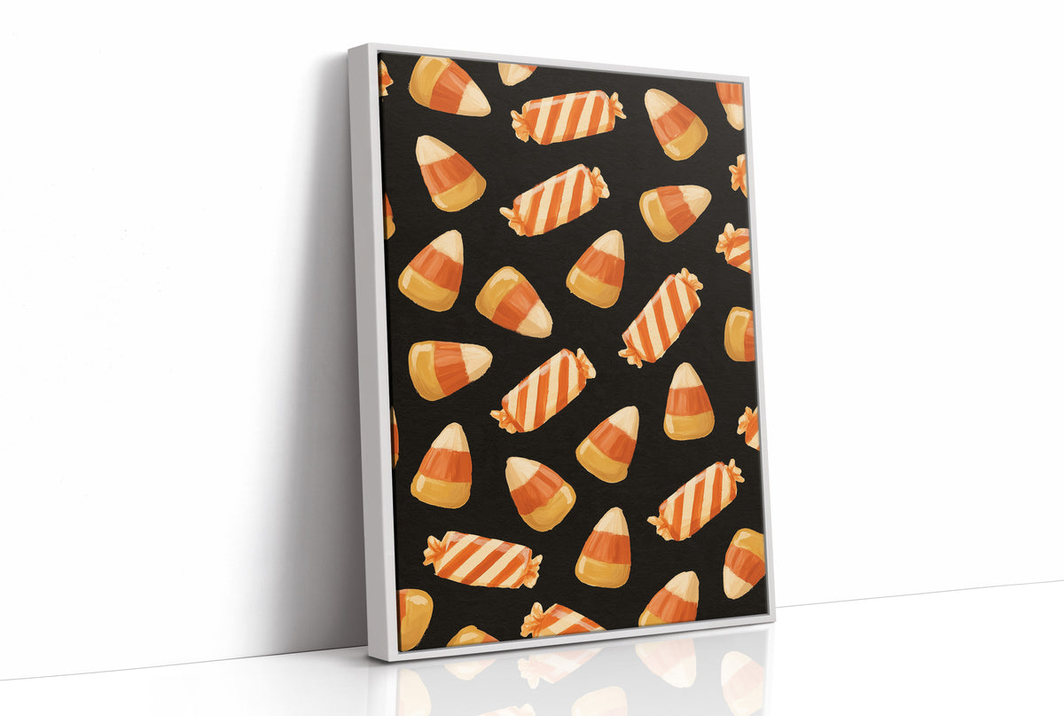 Stripes Kept for Later, a repeating pattern of candy corn kernels in cream, orange and butter yellow on a deep black ground, as a framed canvas in a white frame