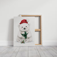 The Bear Cub Keeps a Secret, a small polar bear cub in a red knit hat hugging a green wrapped gift with a sprig of holly at its feet, on a soft cream ground, on a gallery canvas with wrapped edges leaning against a white wall