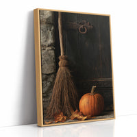 The Broom Waits by the Door, a straw broom leaning in a dim corner beside a single orange pumpkin, painted in charcoal, rust and amber, as a framed canvas in a natural wood frame