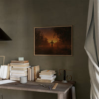 The Field Keeps Its Last Light, a scarecrow standing in a rural sunset field of amber sky and rust colored grass, painted in burnt orange, dusky gold and deep brown, in a thin wood frame on a moss green wall above a desk stacked with books