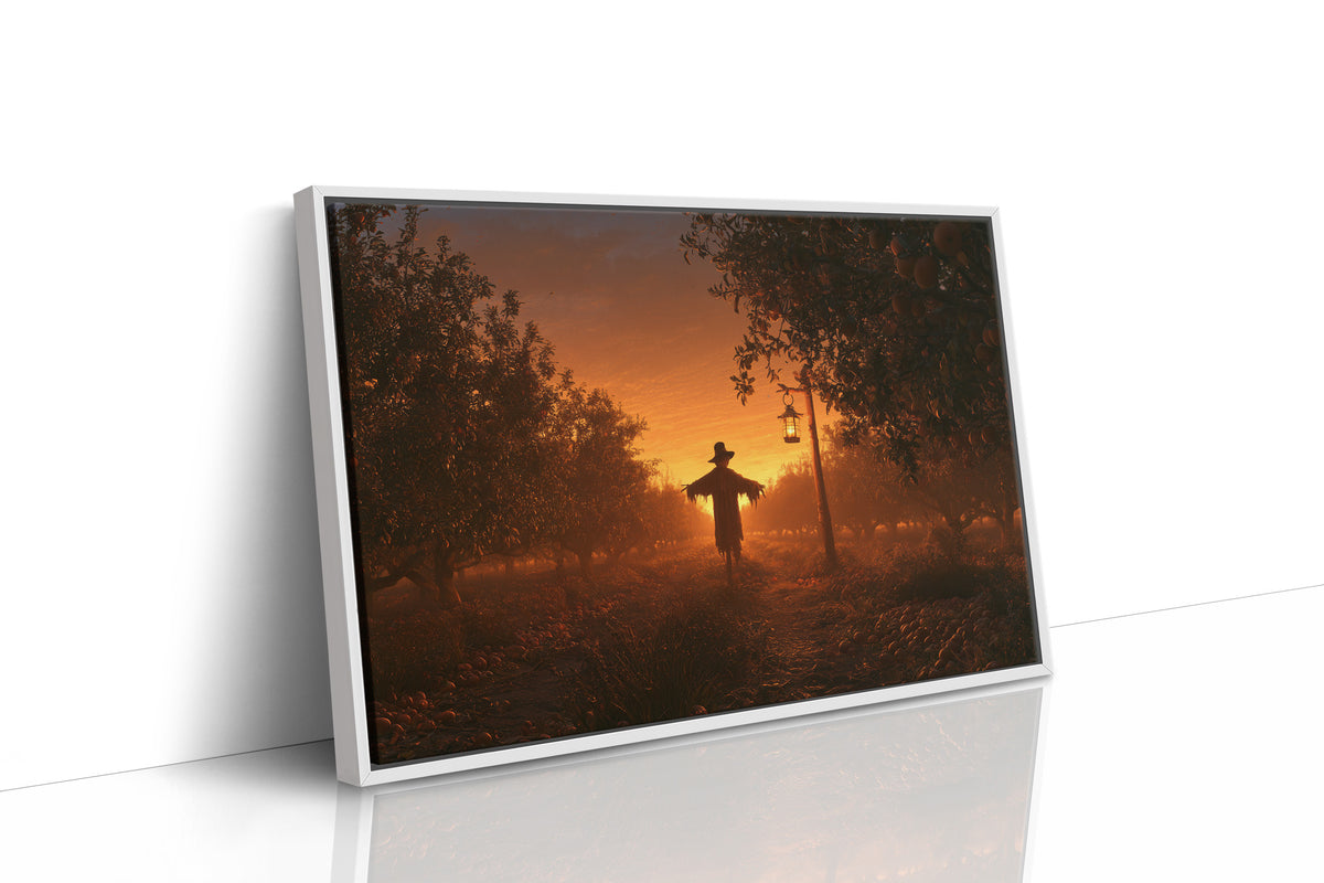 The Field Keeps Its Last Light, a scarecrow standing in a rural sunset field of amber sky and rust colored grass, painted in burnt orange, dusky gold and deep brown, as a framed canvas in a white frame