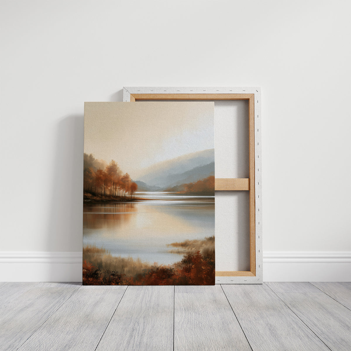 The Lake Remembers Autumn, an autumn lake at dusk with a line of turning trees on the near shore and pale mountains beyond, the water mirroring the sky in soft blue and amber, on a gallery canvas with wrapped edges leaning against a white wall