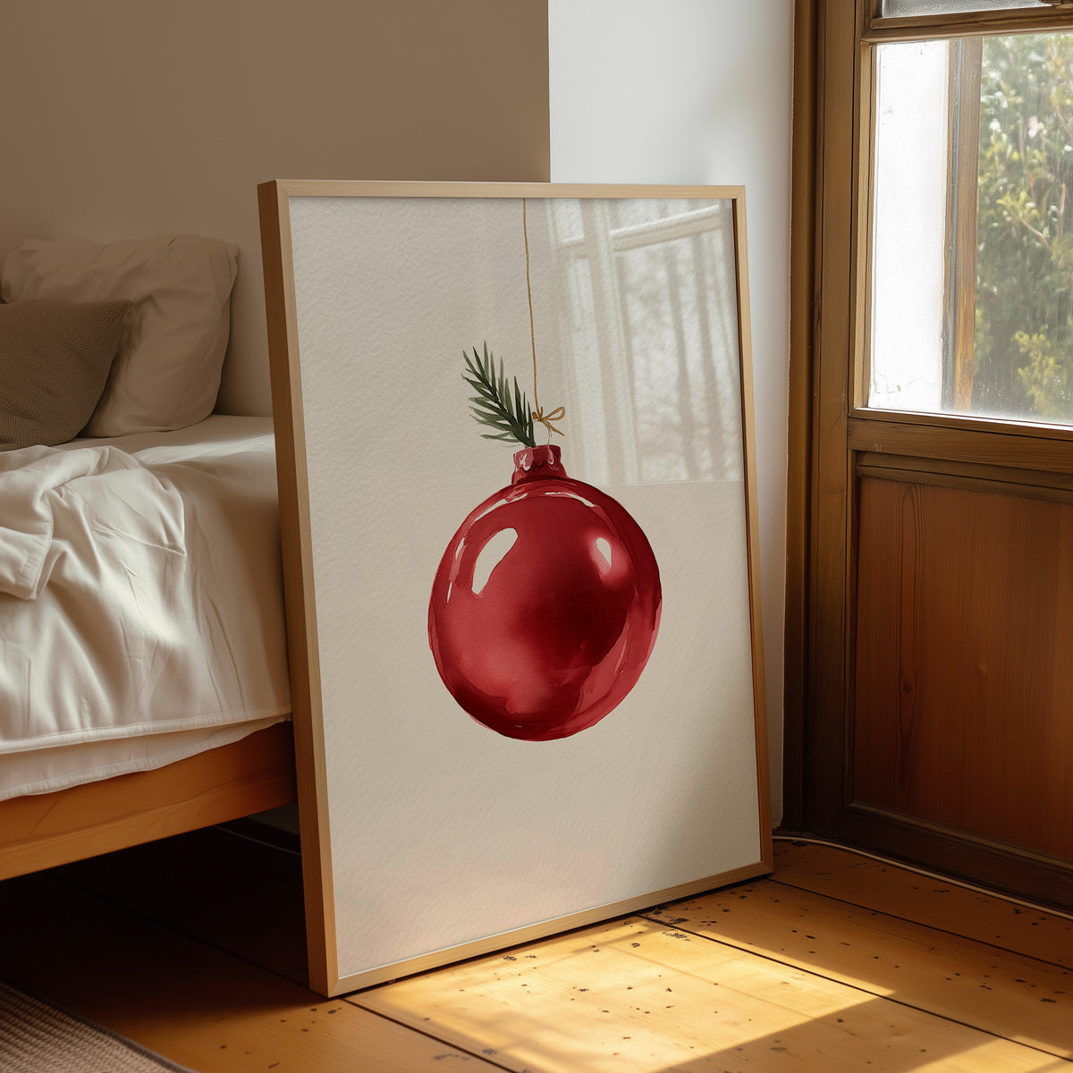 The Last Bauble on the Branch, a single red glass ornament hanging from a thin cord with a sprig of pine tip, on a cream ground, leaning on a wood floor in a bedroom beside white linen bedding