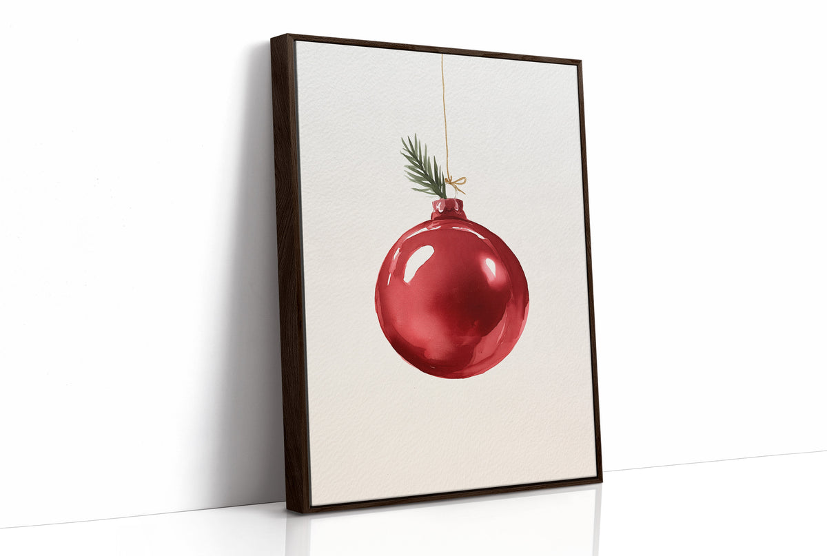 The Last Bauble on the Branch, a single red glass ornament hanging from a thin cord with a sprig of pine tip, on a cream ground, as a framed canvas in a brown frame
