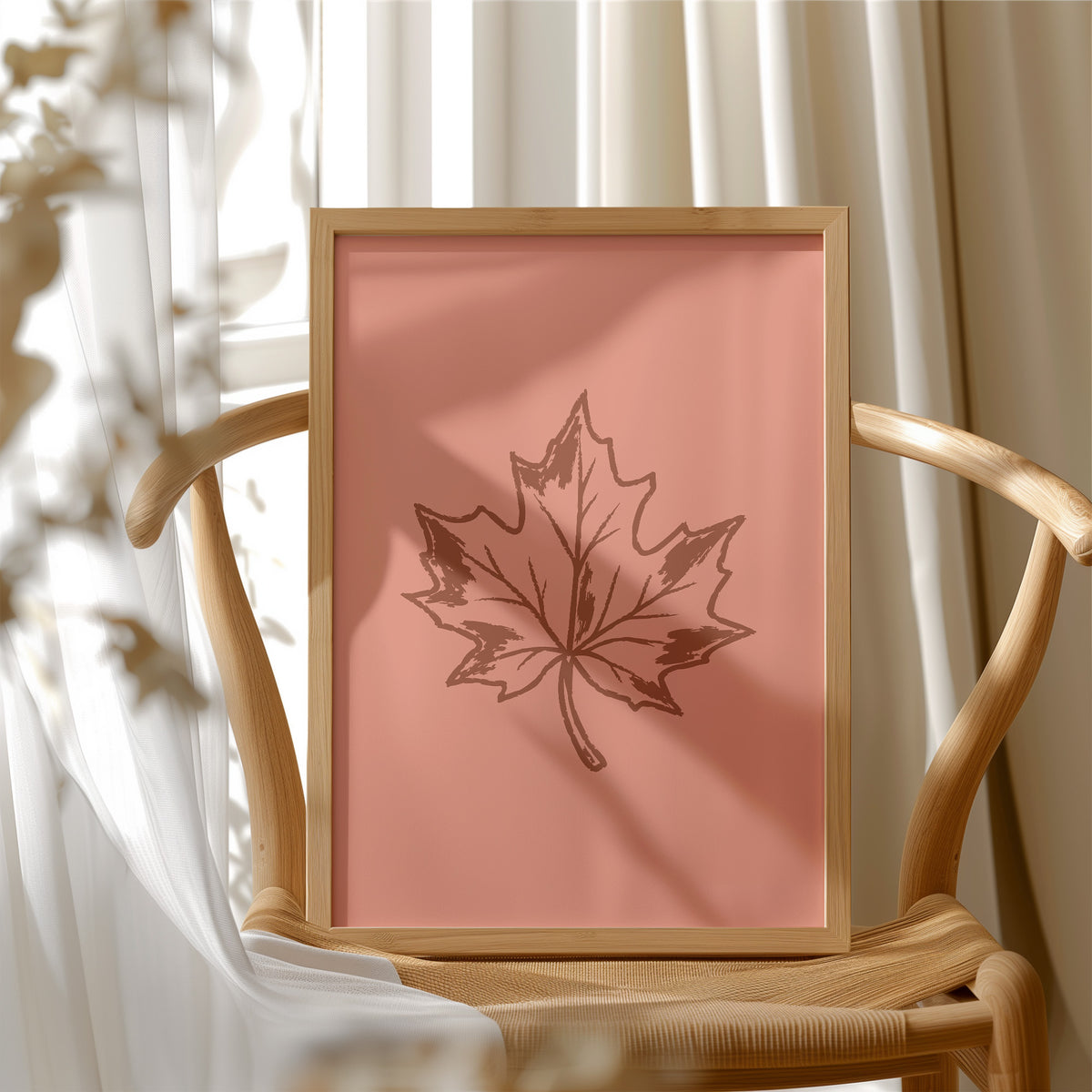 The Maple Keeps Its Last Light, a single maple leaf drawn in fine brown outline on a dusty terracotta ground, a botanical line study with soft shading, in a wood frame beside a wicker chair by a sunny window