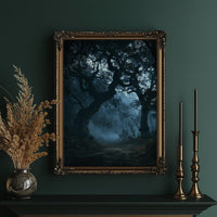 The Old Oak Keeps Its Midnight, gnarled trees rising out of a blue mist on a moonlit night, painted in deep navy, pale fog and charcoal shadow, in an ornate gold frame on a deep green wall beside brass candlesticks