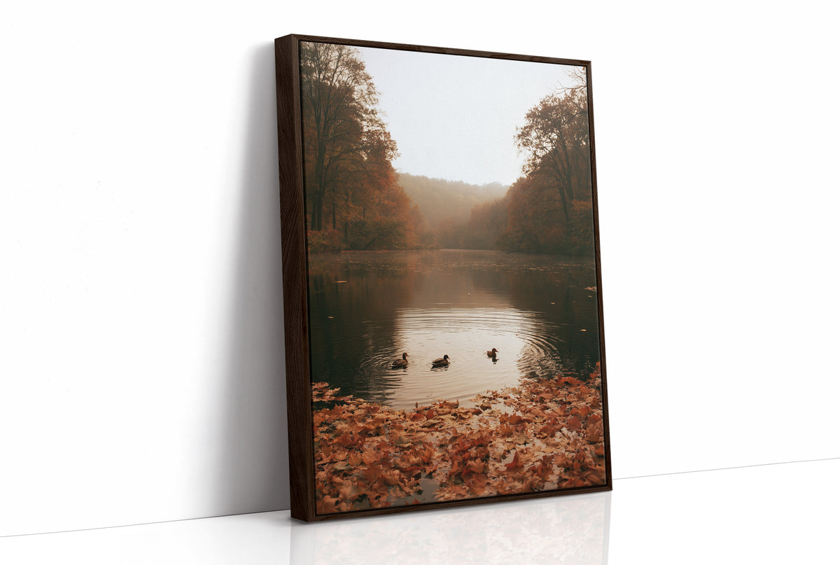 The Pond Keeps Its Quiet Company, two ducks on a still misty lake among rust trees, a bank of fallen autumn leaves in the foreground, painted in rust, forest green and soft gold, as a framed canvas in a brown frame