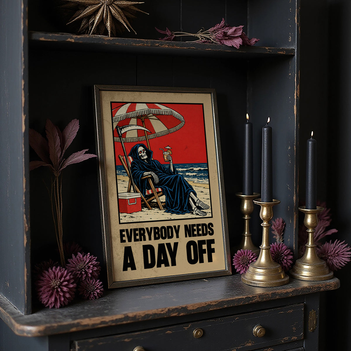 The Reaper Takes a Day Off, a hooded grim reaper in a deck chair under a striped umbrella on a red and cream beach poster, with the lettering EVERYBODY NEEDS A DAY OFF in bold black and tan below, in a retro print style, on a dark cabinet shelf beside black candles and dried flowers