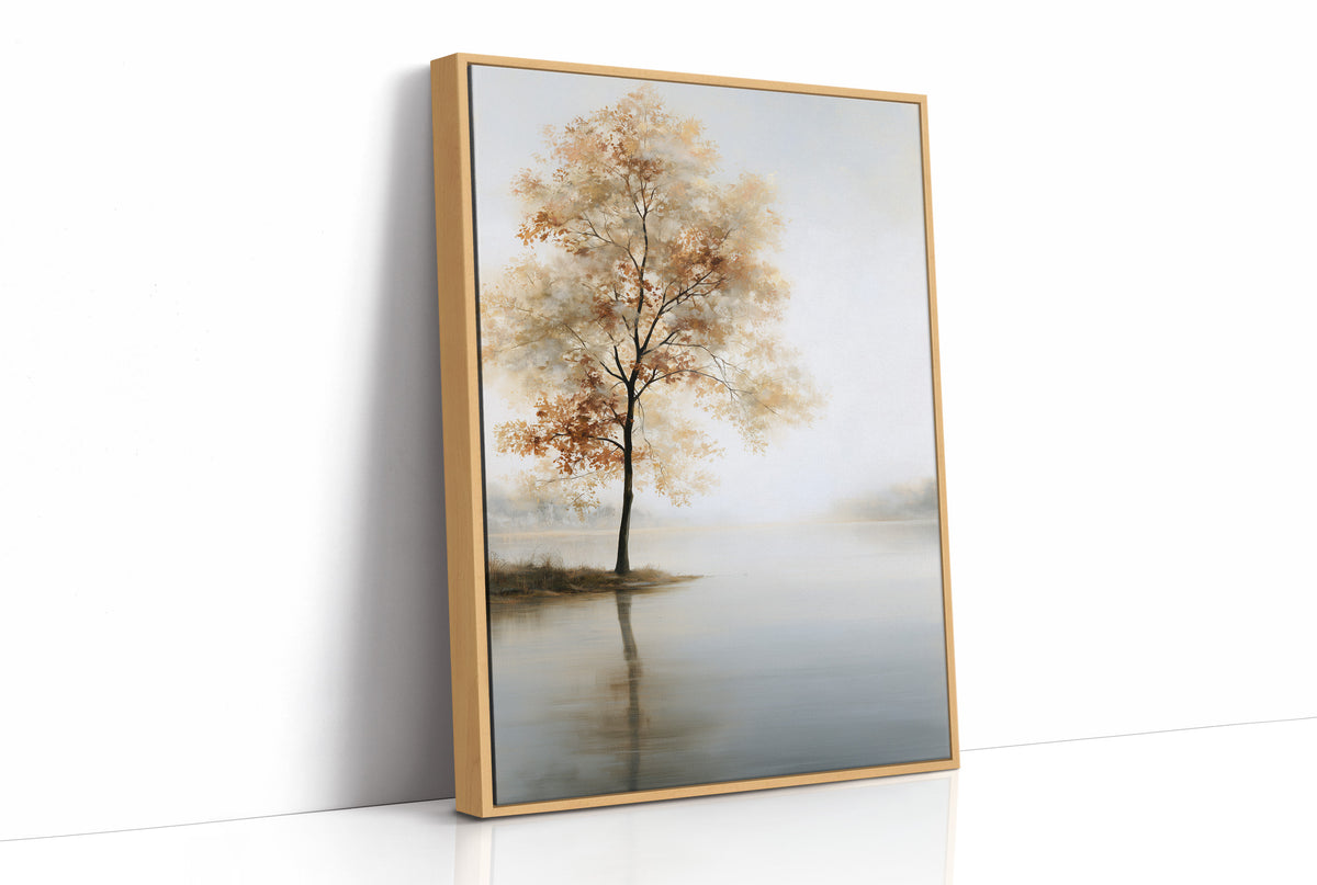 The Tree Stays Put in the Mist, a single tree with autumn gold in its crown standing on the edge of a pale lake, with the mist rolling low over the water and the sky a soft cream and blue, as a framed canvas in a natural wood frame