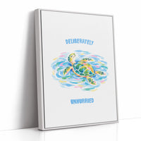 The Turtle Keeps Its Own Time, a sea turtle drifting over pale blue and green watercolor waves, with two lines of bold blue lettering above and below it on a white ground, in a soft watercolor style, as a framed canvas in a white frame