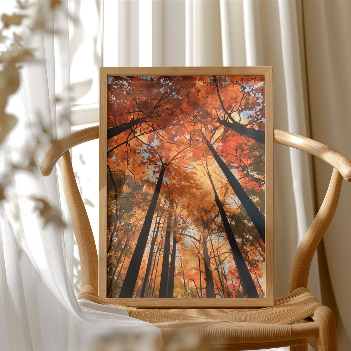 The Woods Blaze Overhead, a looking up view of tall trees with fiery red and orange autumn canopy and a sky of soft light, painted in flame red and burnt gold, in a wood frame beside a wicker chair by a sunny window