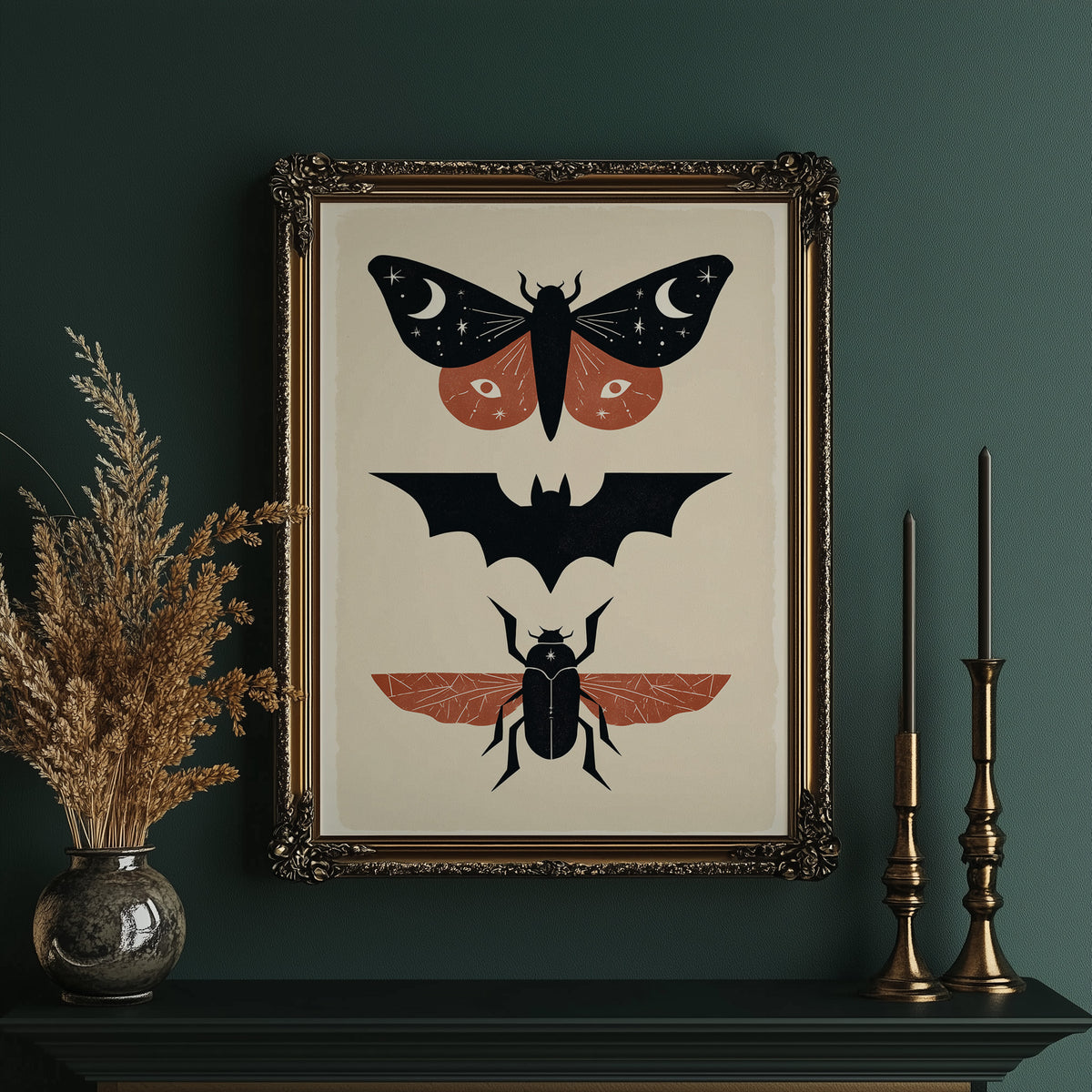 Three Night Visitors in a Row, a moth with crescent moon spots, a black bat in flight and a beetle with rust wings stacked in a column on a cream ground, painted in black, rust and cream, in an ornate gold frame on a deep green wall beside tall brass candlesticks