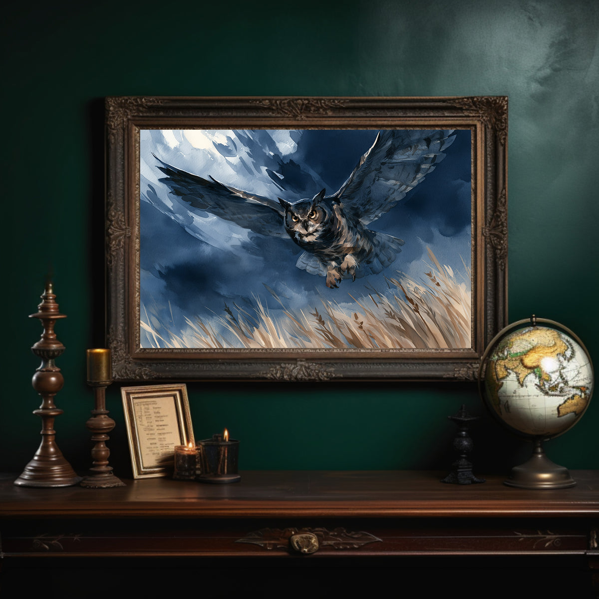 Through the Storm on Silent Wings, an owl in flight low over golden grass beneath a blue and cloud dark storm sky, in an ornate dark frame on a deep green wall above a mantel with a globe and candles