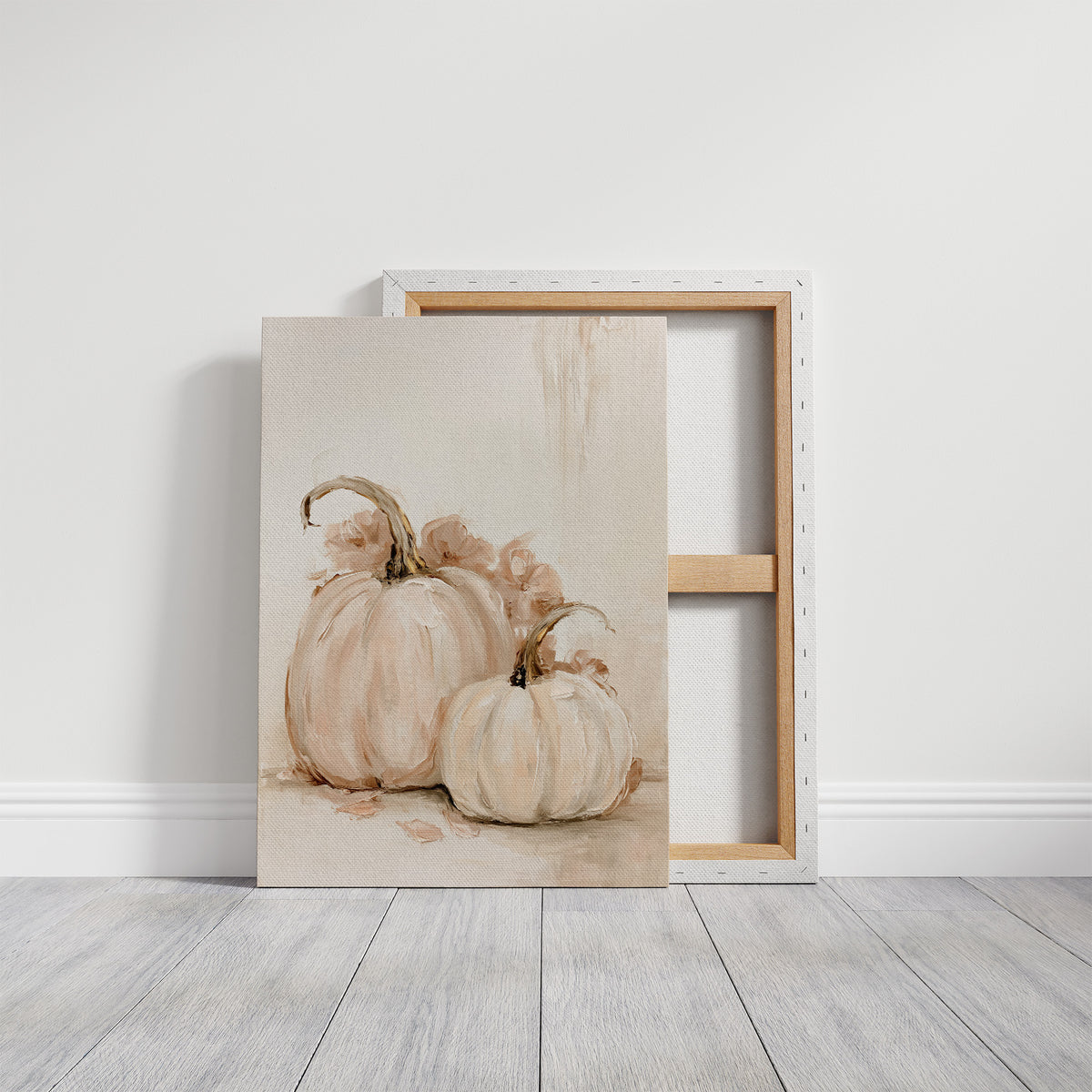 Two Pale Gourds Keep Company, two white pumpkins with curling stems and soft peach shadows on a cream ground, painted in ivory, blush and sage, on a gallery canvas with wrapped edges leaning against a white wall