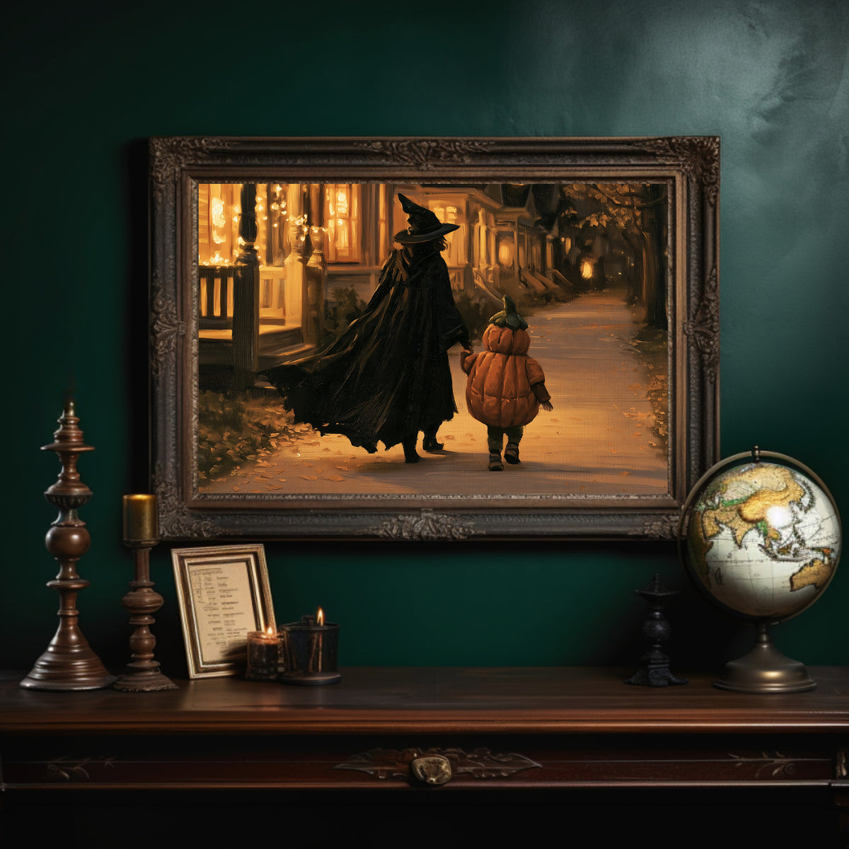 Two Shadows Walk the Lamplit Street, witch and a small child in pumpkin costume walking a lamp lit street painting, in an ornate dark frame on a deep green wall above a mantel with a globe and candles