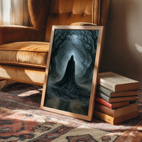 Veiled Beneath the Bending Trees, a hooded robed figure standing at the end of a tunnel of bare trees in pale blue fog, in a wood frame beside a leather armchair and a stack of books