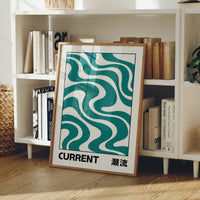 Where the Current Turns Gently, a bold teal wave pattern of stacked curving bands in cream and dark teal, with the word CURRENT in black block letters and a small kanji beside it, in a clean retro poster style, in a wood frame on a white bookshelf beside stacked magazines and a plant