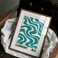 Where the Current Turns Gently, a bold teal wave pattern of stacked curving bands in cream and dark teal, with the word CURRENT in black block letters and a small kanji beside it, in a clean retro poster style, in a wood frame on a black leather armchair beside a sheet of tissue paper