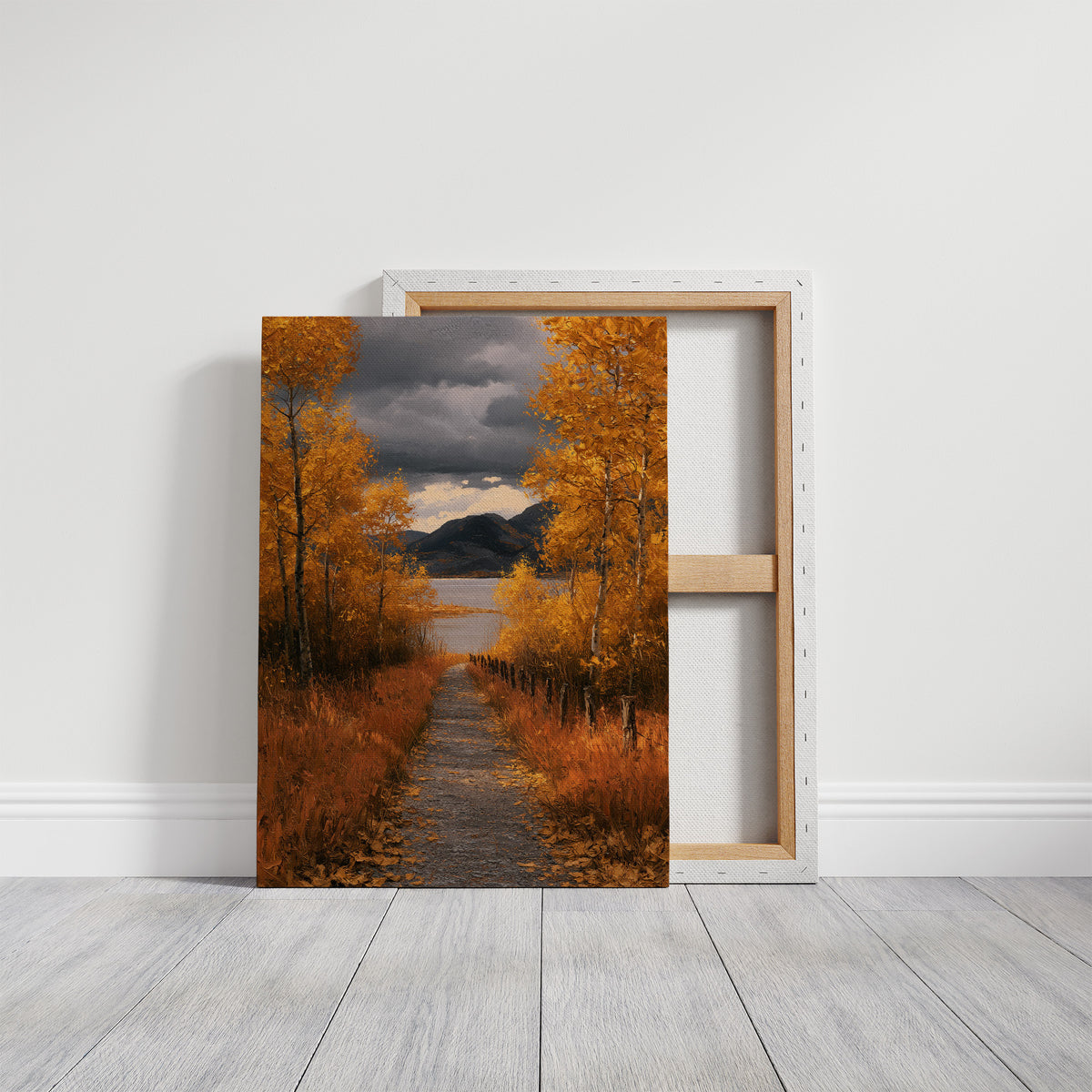 Where the Storm Lets Go of the Lane, a dirt lane between gold birches toward soft mountains under a clearing gray sky, painted in amber, slate and rust, on a gallery canvas with wrapped edges leaning against a white wall