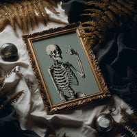 Bone Voyage, You’ve Got This, framed print leaning on a leather armchair beside a stack of books