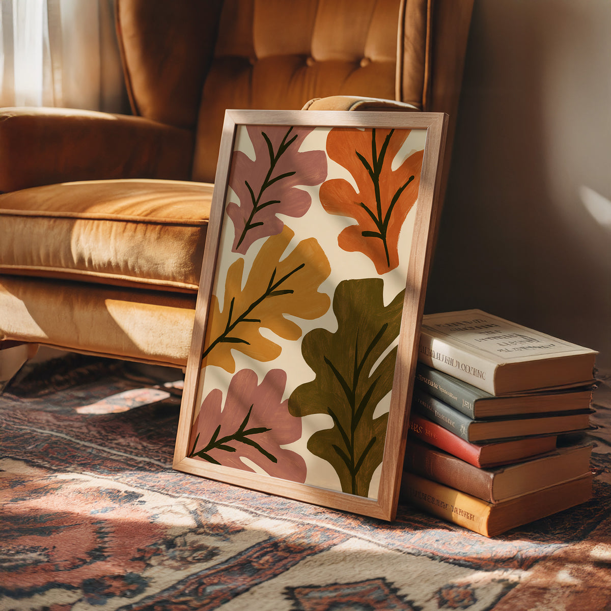 Big Leaf Energy, framed print leaning on a leather armchair beside a stack of books