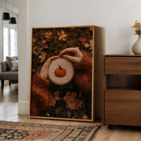 Hoop Dreams, Pumpkin Edition, large framed print leaning on a white wall beside a wood cabinet