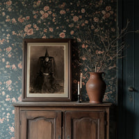 Formal Portrait, Informal Spiders, framed print resting on a wooden chair beside sheer curtains